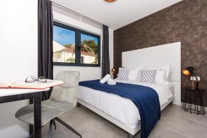 - une chambre avec un lit, un bureau et une fenêtre dans l'établissement Villa Royal, à Trogir