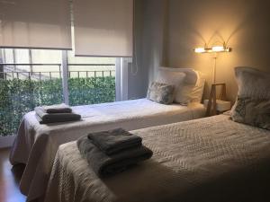 1 dormitorio con 2 camas y toallas. en Studio Juncal en Buenos Aires