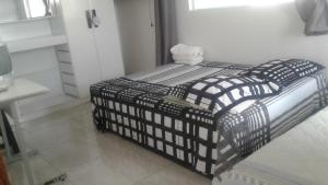 a black and white bed in a room at Apt Penedo in Penedo