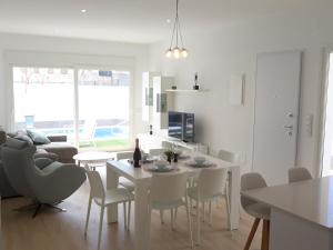 a white kitchen and living room with a table and chairs at Villa Pinatar in San Pedro del Pinatar
