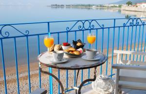 a table with a bowl of fruit and two glasses of orange juice at Villa "Pietra e Mare" in Nafpaktos