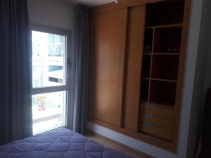 1 dormitorio con ventana, vestidor y cama en Fuerteventura Port Sea, en Morro del Jable