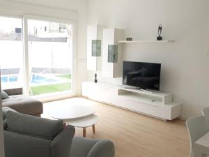 a living room with a tv and a couch and a table at Villa Pinatar in San Pedro del Pinatar