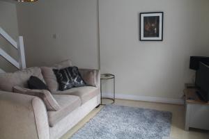 ein Wohnzimmer mit einem Sofa und einem TV in der Unterkunft Kyme Street, central York in York