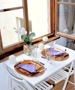 una mesa blanca con platos y servilletas. en Le Moment Bleu, en Estrasburgo