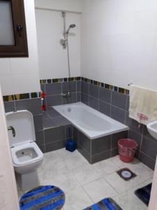 een badkamer met een bad, een toilet en een wastafel bij Clara Apartment in Alexandrië