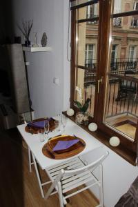 a table with wine glasses and a plate on it at Le Moment Bleu in Strasbourg