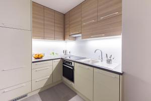 a kitchen with white cabinets and a sink at Raval Apartments - Soft Black in Rewal