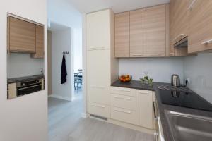 a kitchen with wooden cabinets and black counter tops at Raval Apartments - Soft Black in Rewal