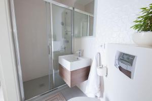 een badkamer met een wastafel, een douche en een toilet bij Raval Apartments - Soft Black in Rewal