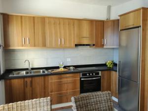 a kitchen with wooden cabinets and a stainless steel refrigerator at Residencial LaMar in Santa Cruz de la Palma +26 photos