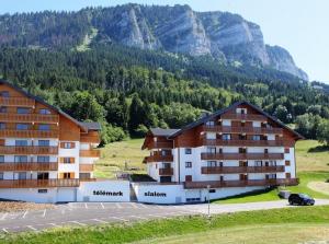 a hotel in the mountains with a parking lot at Chalet Le Telemark in Thollon