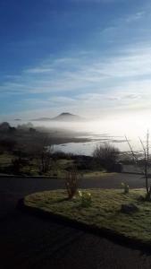 a view of a lake with a hill in the distance at Rossroe Lodge B&B in Canower