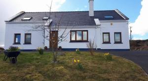une maison blanche avec un jardin en face dans l'établissement Rossroe Lodge B&B, à Canower