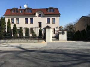 a white house with a gate and a fence at Apartamenty AP 8 in Częstochowa
