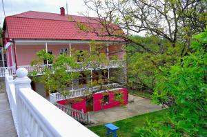 a house with a red roof and a white fence at Sofia Guest House in Kutaisi