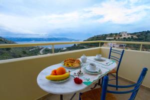 a table with a breakfast of fruit on a balcony at Villa Alkyon in Megála Khoráfia