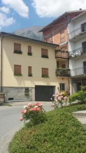 un grand bâtiment avec des fleurs devant lui dans l'établissement valtellinadeicech, à Mello