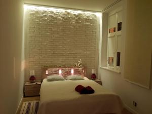ソポトにあるHouseboat Apartmentのレンガの壁に照明付きのベッドが備わるベッドルーム1室が備わります。