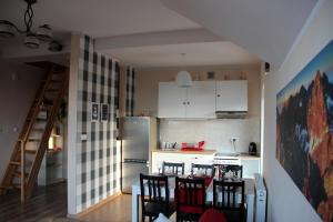 a kitchen with a table and chairs and a refrigerator at Makadamia Karpacz in Karpacz