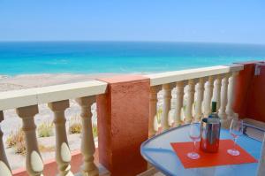 a glass table on a balcony with a view of the ocean at Residencial Playa Paraiso in Costa Calma