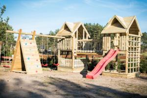 a wooden playground with a slide and a climbing frame at Domki w Borach in Wycinki