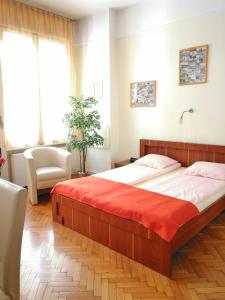 a bedroom with a large bed with a red blanket at Paprika Apartment Studio in Budapest