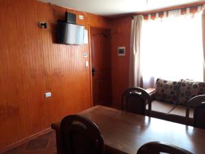a dining room with a table and a couch at Cabañas Flores del sur in Llanquihue