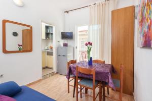 a dining room with a table and a kitchen at Vila Nela in Tučepi