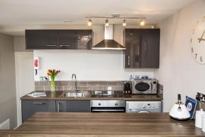 a kitchen with a sink and a microwave at Galtres Chambers Apartment Coppergate in York