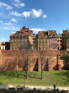a group of buildings in front of a brick wall at Apartament MnW in Warsaw
