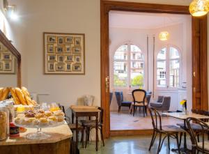 a room with a table with pastries and chairs at Mihlton Barcelona Boutique B&B in Barcelona