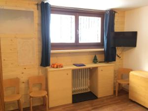 Habitación con escritorio y ventana con radiador. en Appartamento Saint Theodule, en Breuil-Cervinia