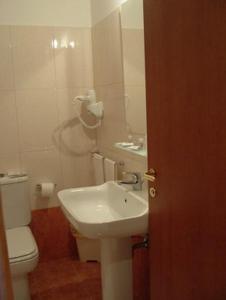 a bathroom with a sink and a toilet and a mirror at Hotel GF in Cesano Boscone