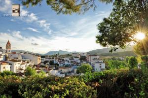 un paisaje urbano de una ciudad con el sol en el cielo en Casa El Paseo, en Arriate