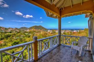 a porch with a chair and a view of the mountains at Paradise Cove in Gros Islet