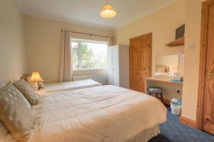 a bedroom with a bed and a desk and a window at Fortview Guest House in Enniscrone