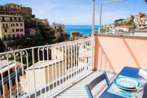 een balkon met een tafel en uitzicht op de oceaan bij Live in The Heart of 5 Terre in Riomaggiore