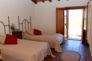 a bedroom with two beds and a door to a patio at Casa Do Alto Da Eira in Albergaria dos Fusos