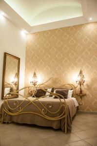 ナポリにあるDomus Sanfelice Suiteのベッドルーム1室(金枠のベッド1台付)