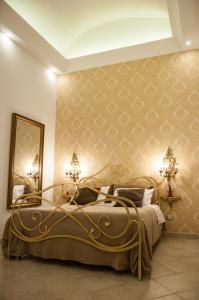 ナポリにあるDomus Sanfelice Suiteのベッドルーム1室(金の壁紙を使用した大型ベッド1台付)