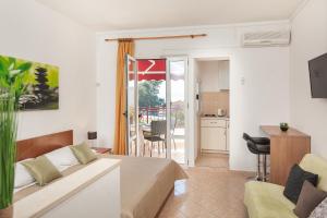 a living room with a couch and a kitchen at Vila Nela in Tučepi