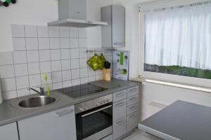 una piccola cucina bianca con lavandino e finestra di Bernkasteler Moselpanorama a Bernkastel-Kues