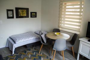 a small room with a bed and a table and chairs at Apartment Fortuna in Visoko