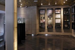 a room with a display of wine bottles on a wall at Hotel Bagués, a Small Luxury Hotel of the World in Barcelona