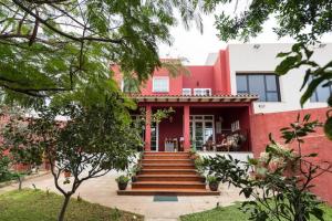 una casa roja con escaleras que conducen a la puerta principal en Casa El tonelero con jardín y piscina privada, en Gáldar