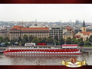 
a red double decker bus driving down a river at Botel Albatros in Prague
