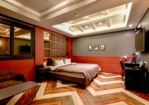 Dormitorio con cama, escritorio y TV en French code Hotel, en Changwon