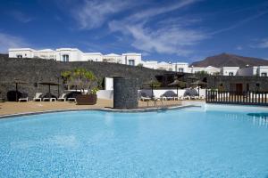 a large swimming pool in front of a building at Apartamentos LIVVO Coloradamar in Playa Blanca