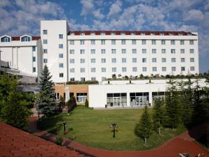 duży biały budynek z parkiem przed nim w obiekcie Bilkent Hotel and Conference Center w mieście Ankara